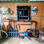 Local technique de piscine complet avec filtration, pompe, traitement automatique Dryden Aqua et installation hydraulique professionnelle réalisée par Dodin Piscine.